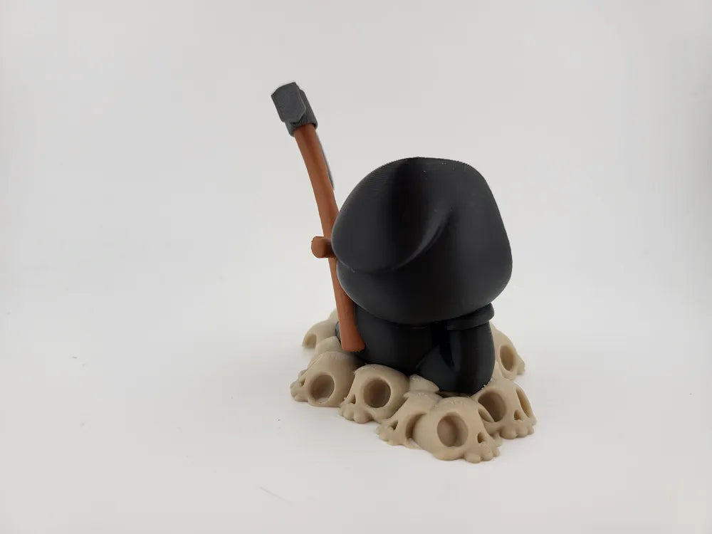 Grim Reaper Relaxing on Skulls – Tristo Mietitore sui Teschi