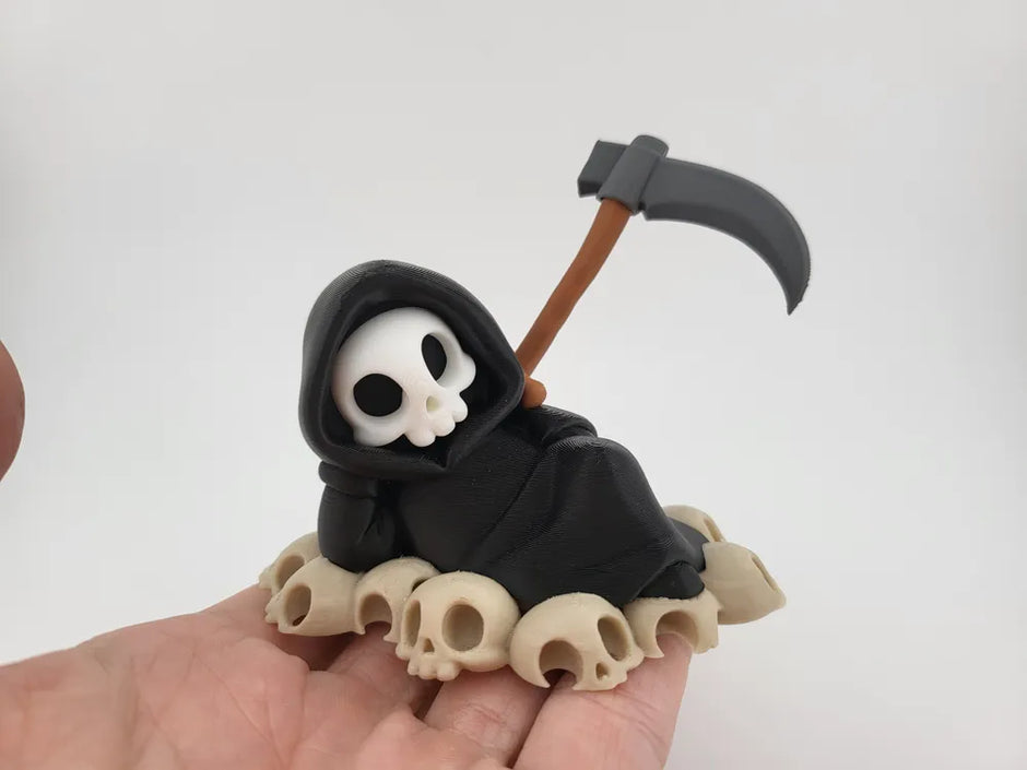 Grim Reaper Relaxing on Skulls – Tristo Mietitore sui Teschi