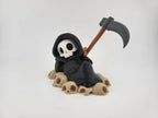 Grim Reaper Relaxing on Skulls – Tristo Mietitore sui Teschi