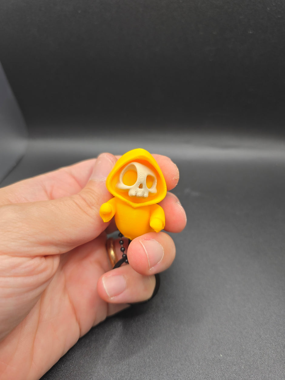 Portachiavi Halloween – Mini scheletro con cappuccio giallo